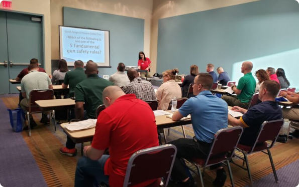A classroom setting with an instructor giving a presentation to a group of seated students.